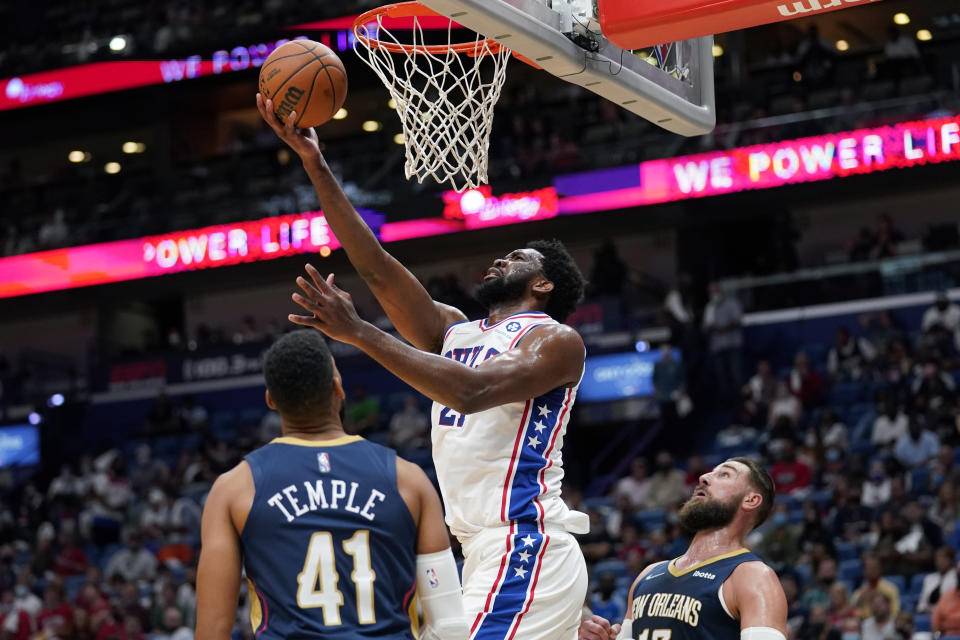 Philadelphia 76ers center Joel Embiid (21) goes to the basket over New Orleans Pelicans forward Garrett Temple (41) in the first half of an NBA basketball game in New Orleans, Wednesday, Oct. 20, 2021. (AP Photo/Gerald Herbert)