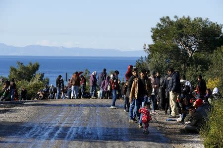 Syrian refugees wait on a roadside near a beach in the western Turkish coastal town of Dikili, Turkey, after Turkish Gendarmes prevented them from sailing off for the Greek island of Lesbos by dinghies, March 5, 2016. REUTERS/Umit Bektas