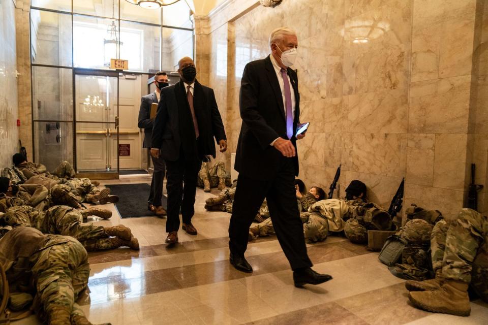 <p>House Majority Leader Steny Hoyer (D-MD) walks past members of the National Guard sleeping in the halls of Capitol Hill on January 13, 2021 in Washington, DC.</p>