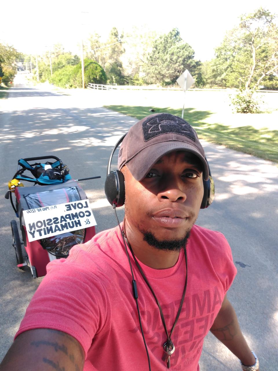 Pascha Morgan stops to take a selfie with his cart in the background during his 2019 walk from Iowa to Texas to protest the treatment of immigrants at the southern U.S. border.