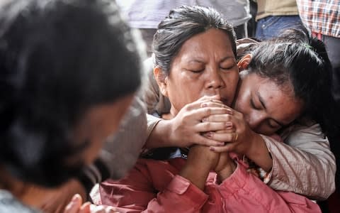Women mourn for their missing family members  - Credit: IVAN DAMANIK/AFP/Getty Images
