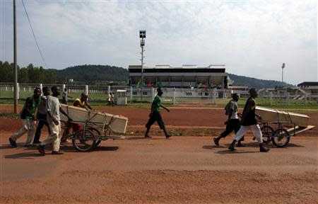 Men push carts loaded with coffins in Bangui December 9, 2013. REUTERS/Emmanuel Braun