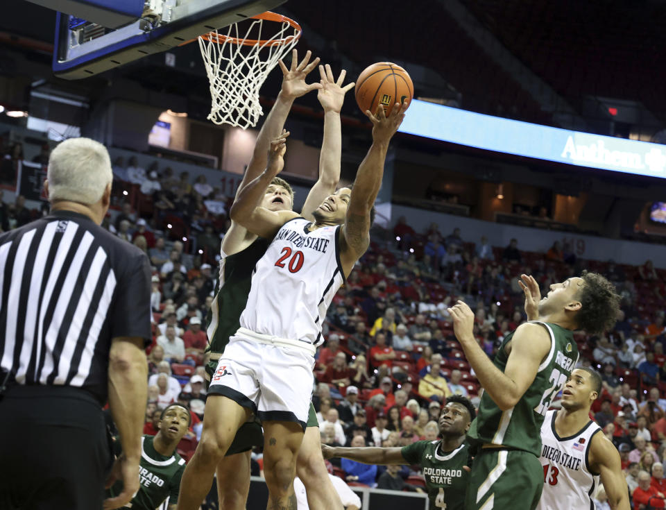 San Diego State guard Matt Bradley (20) goes up a shot and is fouled by Colorado State forward James Moors (10) during an NCAA college basketball game in the quarterfinals of the Mountain West Conference Tournament Thursday, March 9, 2023, in Las Vegas. San Diego State won 64-61. (AP Photo/Ronda Churchill)