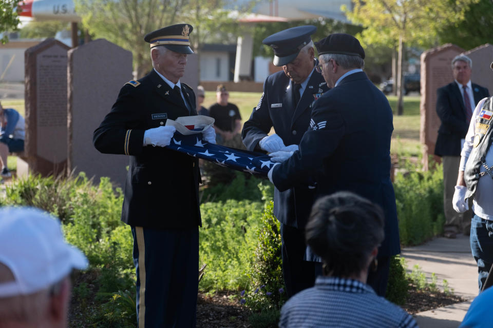 A third shell casing is placed in the folds of a U.S. flag Wednesday evening during the Missing in America's Project ceremony honoring three unclaimed veterans at the Texas Panhandle War Memorial Center in Amarillo.