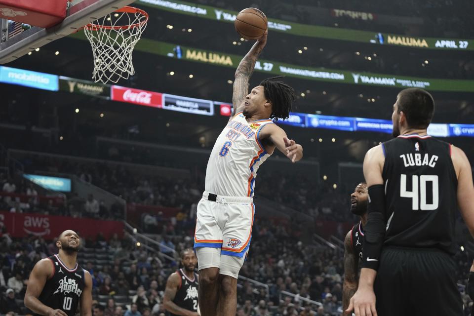 Oklahoma City Thunder forward Jaylin Williams, center, dunks as LA Clippers guard Eric Gordon, left, and center Ivica Zubac defend during the first half of an NBA basketball game Thursday, March 23, 2023, in Los Angeles. (AP Photo/Mark J. Terrill)