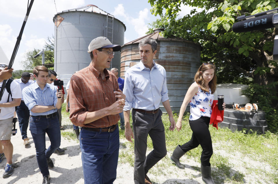 Democratic presidential candidate Beto O'Rourke and his wife Amy walk with Matt Russell, left, whiles touring his Coyote Run Farm, Friday, June 7, 2019, in Lacona, Iowa. (AP Photo/Charlie Neibergall)