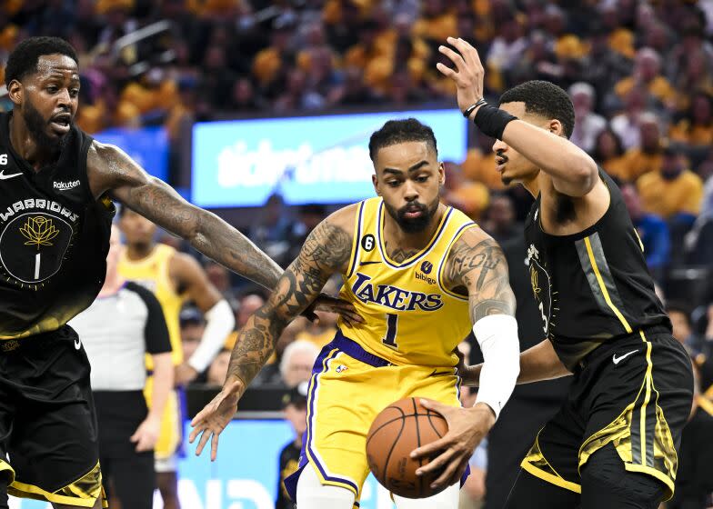 San Francisco, CA - MAY 02: Los Angeles Lakers guard D'Angelo Russell, center, moves the ball between Golden State Warriors forward JaMychal Green, left, and guard Jordan Poole during the second quarter at Chase Center on Tuesday May 2, 2023 in San Francisco, CA.(Wally Skalij / Los Angeles Times)