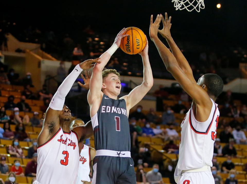 Edmond Memorial's Sean Pedulla puts up a shot between Del City's Sherrod Davis, left, and Brandon Garrison during the Class 6A state  championship game at the Mabee Center in Tulsa on March 13.