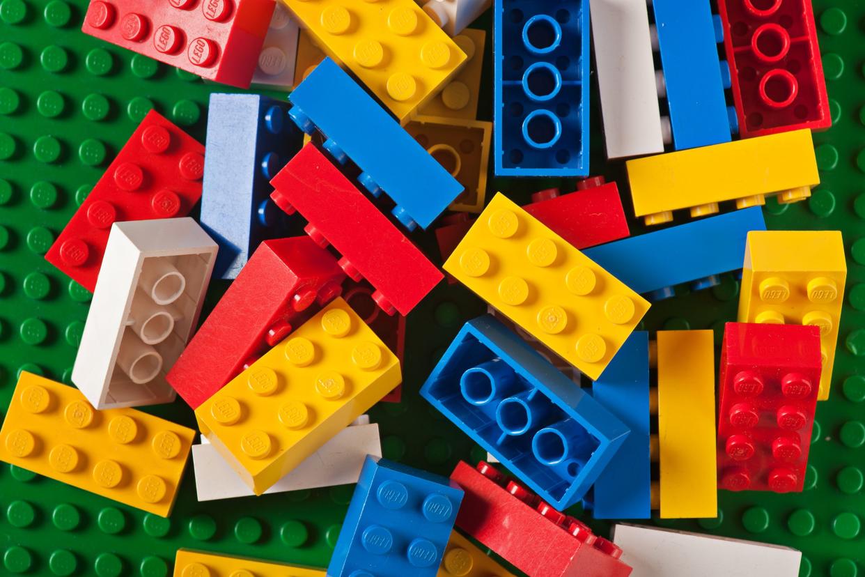 pile of legos against big green lego flat block
