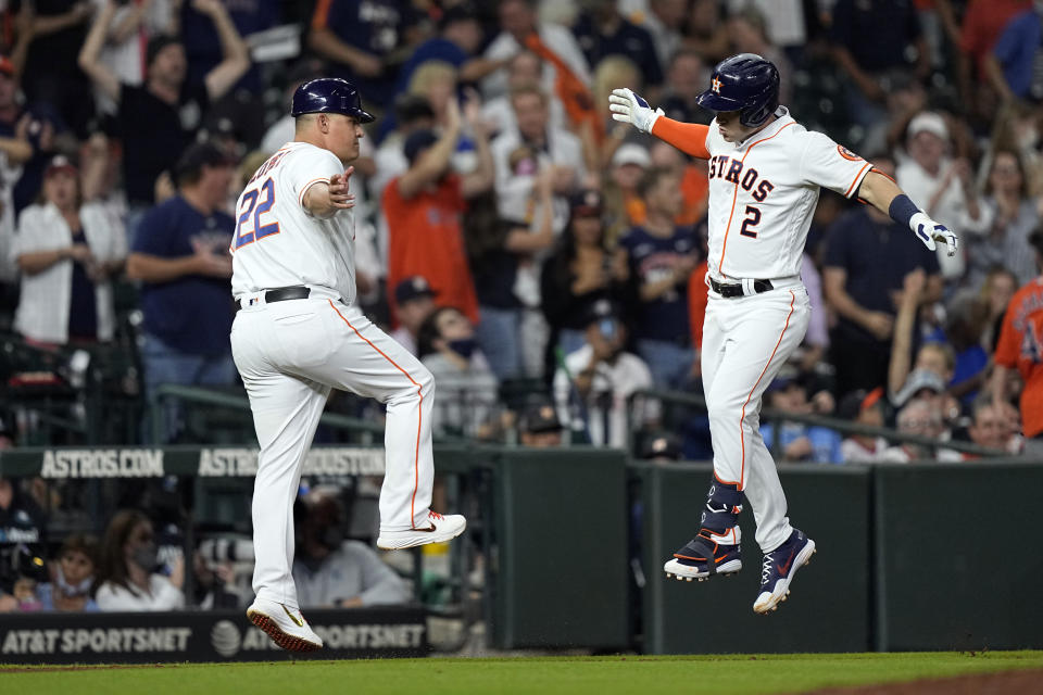 Houston Astros' Alex Bregman (2) celebrates with third base coach Omar Lopez after hitting a home run against the Tampa Bay Rays during the sixth inning of a baseball game Tuesday, Sept. 28, 2021, in Houston. (AP Photo/David J. Phillip)