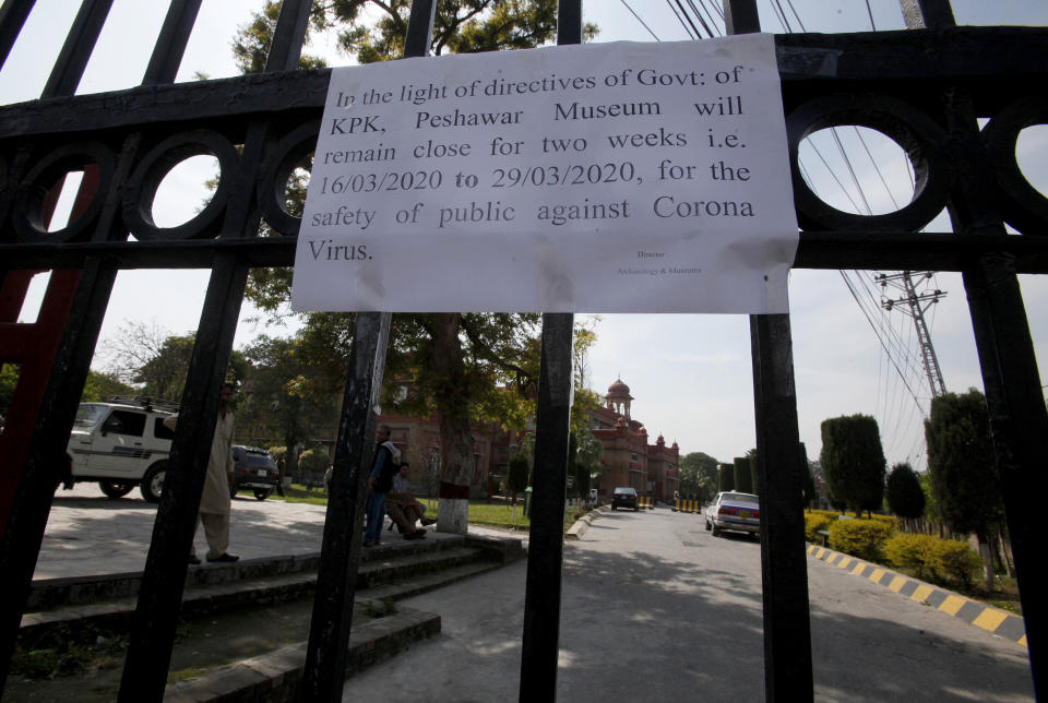 A closure notice hangs on the main gate of the Peshawar Museum as a precautionary measure against the spread of the new coronavirus, in Peshawar, Pakistan, Monday, March 16, 2020. For most people, the new coronavirus causes only mild or moderate symptoms. For some it can cause more severe illness. (AP Photo/Mohammad Sajjad)