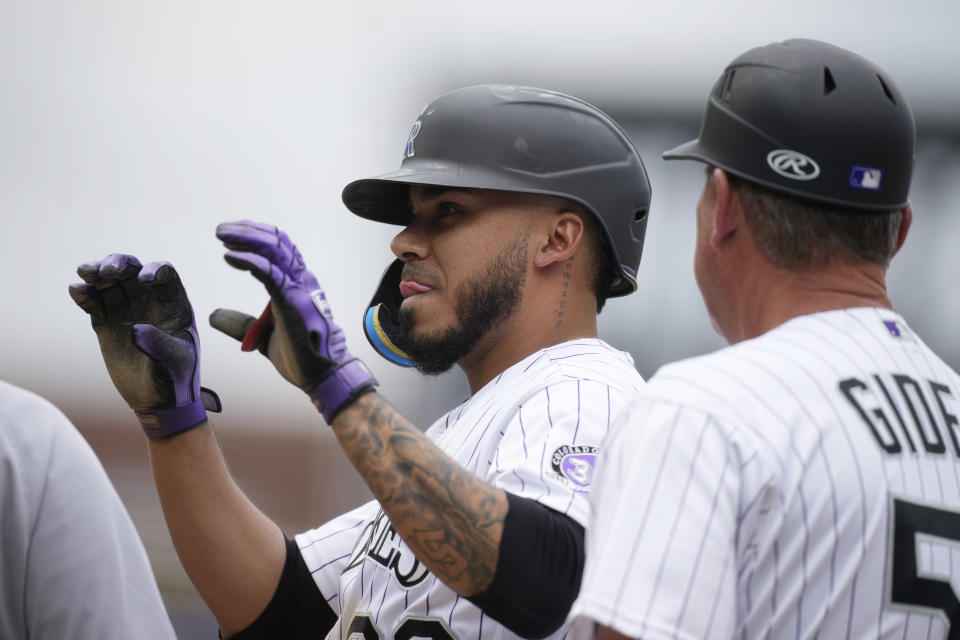 Colorado Rockies pinch-hitter Harold Castro gestures to the dugout after driving in two runs with a single off Milwaukee Brewers relief pitcher Peter Strzelecki in the eighth inning of a baseball game Thursday, May 4, 2023, in Denver. (AP Photo/David Zalubowski)