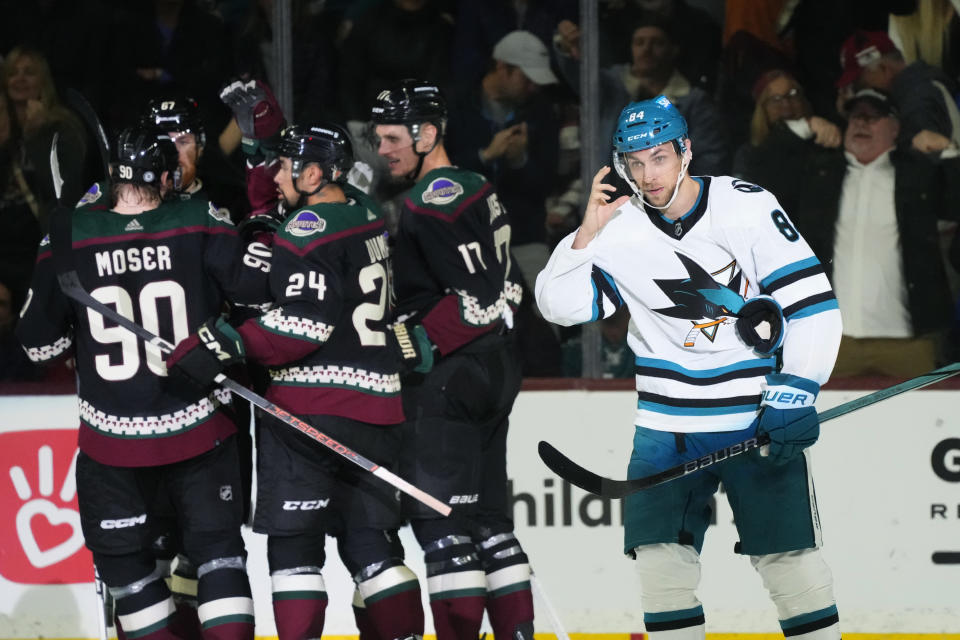 San Jose Sharks defenseman Jan Rutta (84) skates away as Arizona Coyotes defenseman J.J. Moser (90), left wing Lawson Crouse (67), defenseman Matt Dumba (24) and center Nick Bjugstad (17) celebrate a goal by left wing Matias Maccelli during the second period of an NHL hockey game Friday, Dec. 15, 2023, in Tempe, Ariz. (AP Photo/Ross D. Franklin)