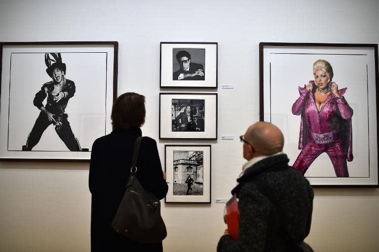 Visitors look at pictures by British photographer David Bailey during the private preview of the exhibition "Stardust" on February 28, 2015 in Milan