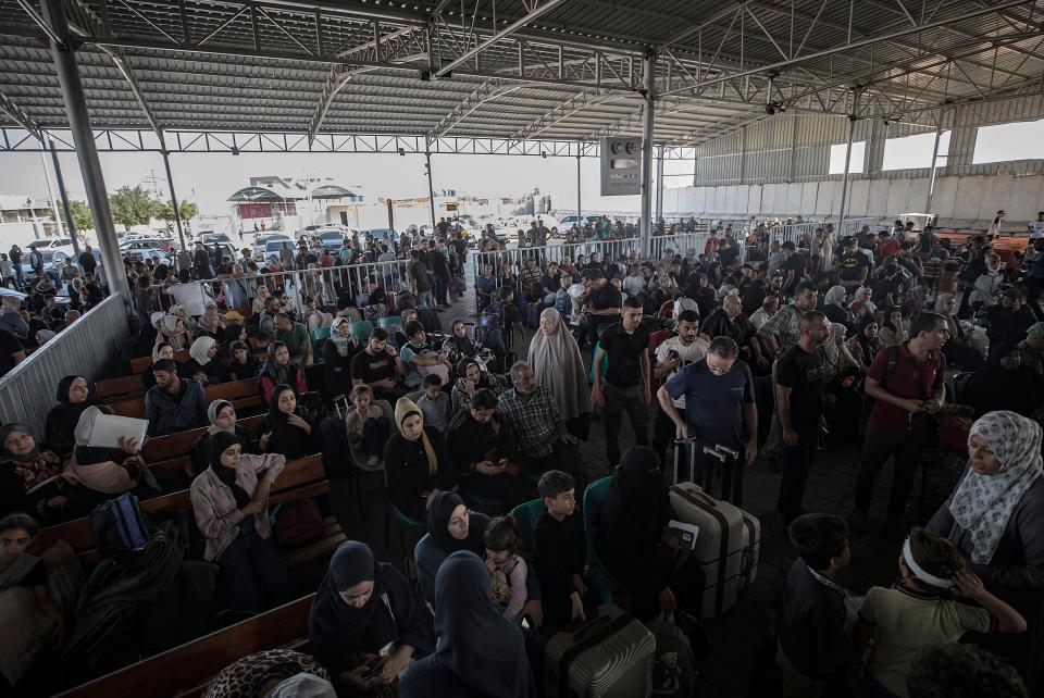 Crowds of people wait to cross into Egypt at the Rafah border (EPA)