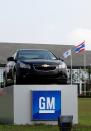 FILE PHOTO: The Thai national flag and a car are displayed vehicle in front of the General Motors (GM) plant in the Eastern Seaboard Industrial Estate in Rayong province February 22, 2011