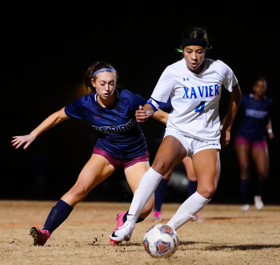 Xavier Prep midfielder Lourdes Lauterborn (4) shields the ball from Perry midfielder Olivia Warmouth (5) during a game at Perry High School.