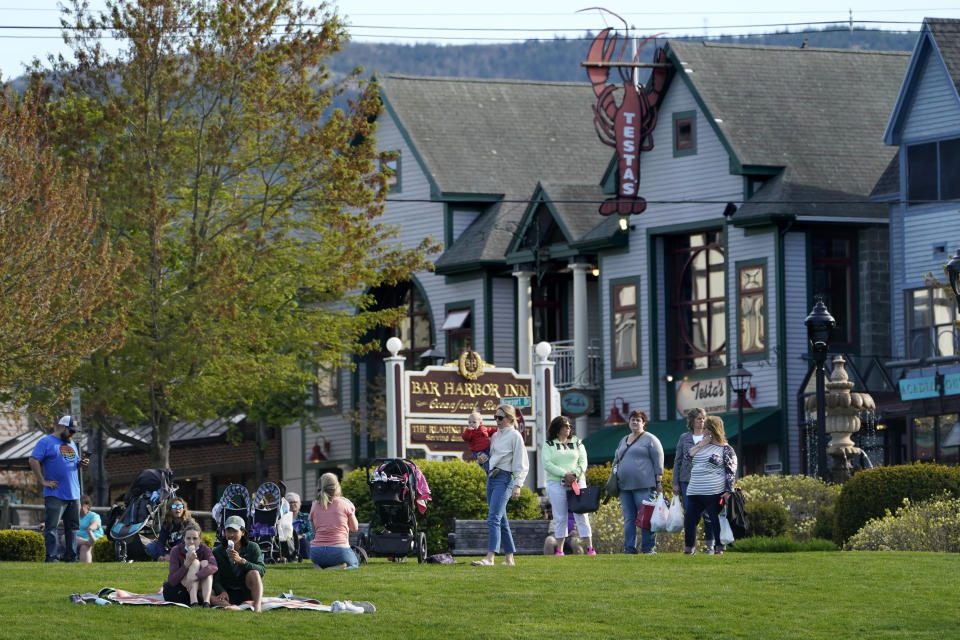 Visitors gather at a waterfront park, Saturday, May 15, 2021, in Bar Harbor, Maine. Gov. Janet Mills is is eliminating most outdoor distancing requirements imposed during the COVID-19 pandemic as the tourism season begins to kick into gear. (AP Photo/Robert F. Bukaty)