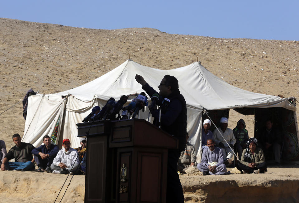 Antiquities Minister Khaled el-Anani speaks during a press conference in front of excavation workers at the site of a recently uncovered tomb of the Priest royal Purification during the reign of King Nefer Ir-Ka-Re, named "Wahtye.", in front of the step pyramid of Saqqara, in Giza, Egypt, Saturday, Dec. 15, 2018. The Egyptian Archaeological Mission working at the Sacred Animal Necropolis in Saqqara archaeological site succeeded to uncover the tomb, Antiquities Minister Khaled el-Anani, announced. (AP Photo/Amr Nabil)