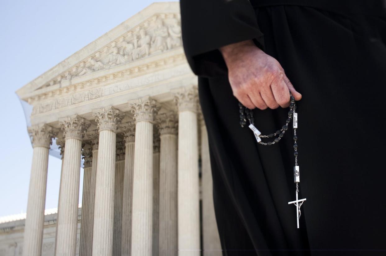 <span class="caption">The ministerial exemptions ruling is one of several cases involving religious employers in front of the Supreme Court.</span> <span class="attribution"><a class="link " href="https://www.gettyimages.com/detail/news-photo/catholic-priest-holds-a-cross-in-front-of-the-supreme-court-news-photo/525595384?adppopup=true" rel="nofollow noopener" target="_blank" data-ylk="slk:Brooks Kraft LLC/Corbis via Getty Images;elm:context_link;itc:0;sec:content-canvas">Brooks Kraft LLC/Corbis via Getty Images</a></span>