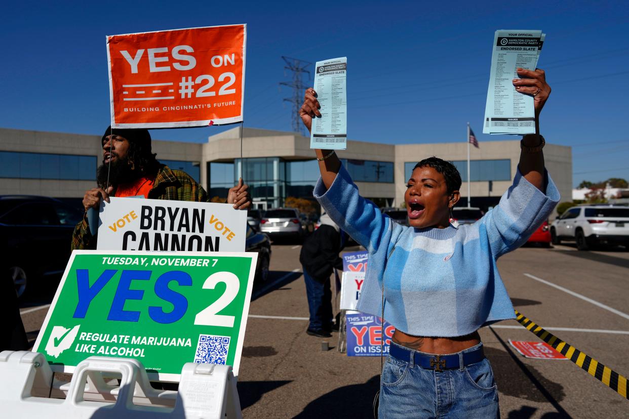 Nikko Griffin, left, and Tyra Patterson, call out to arriving voters in the parking lot of the Hamilton County Board of Elections during early in-person voting in Cincinnati, Thursday, Nov. 2, 2023. They urge people to vote for different issues, including Issue 2, which would allow adult-use sale, purchase, and possession of cannabis for Ohioans who are 21 and older.