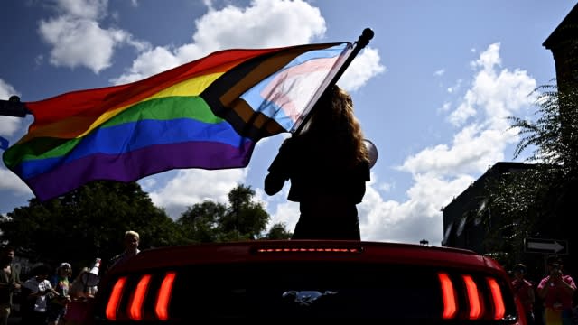 Parade grand marshal Fae Johnstone waves a Pride flag from a convertible during the Capital Pride Parade in Ottawa.