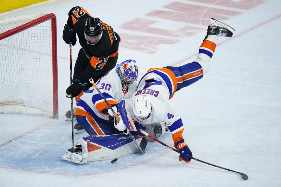 New York Islanders' Ilya Sorokin (30) blocks a shot between Andy Greene (4) and Philadelphia Flyers' Scott Laughton (21 ) during the third period of an NHL hockey game, Sunday, April 18, 2021, in Philadelphia. (AP Photo/Matt Slocum)