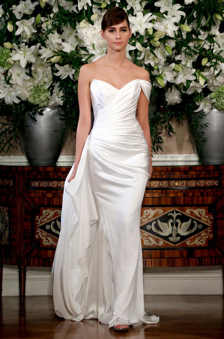 This March 2013 photo released by Romona Keveza shows a sleeveless Romona Keveza Coutour wedding dress. The traditional bridal gown isn't a skimpy silhouette: It's long and typically without a plunging neckline or high slit. There's often a whole lot of fabric. One of the few opportunities for brides to be a little bare is to go with a strapless or sleeveless dress. New bridal collections are dominated by dresses with no sleeves. (AP Photo/Romona Keveza)