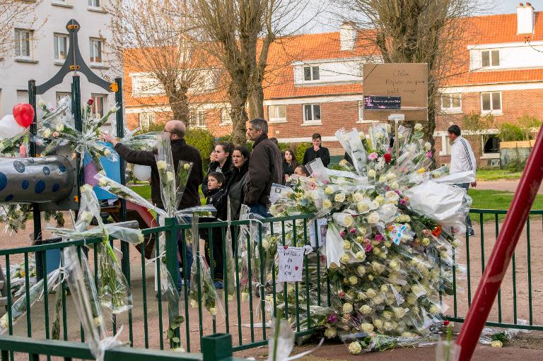 People lay flowers on a playground in homage to Chloe, a nine-year-old girl who was killed a day before, on April 16, 2015 in Calais, northern France