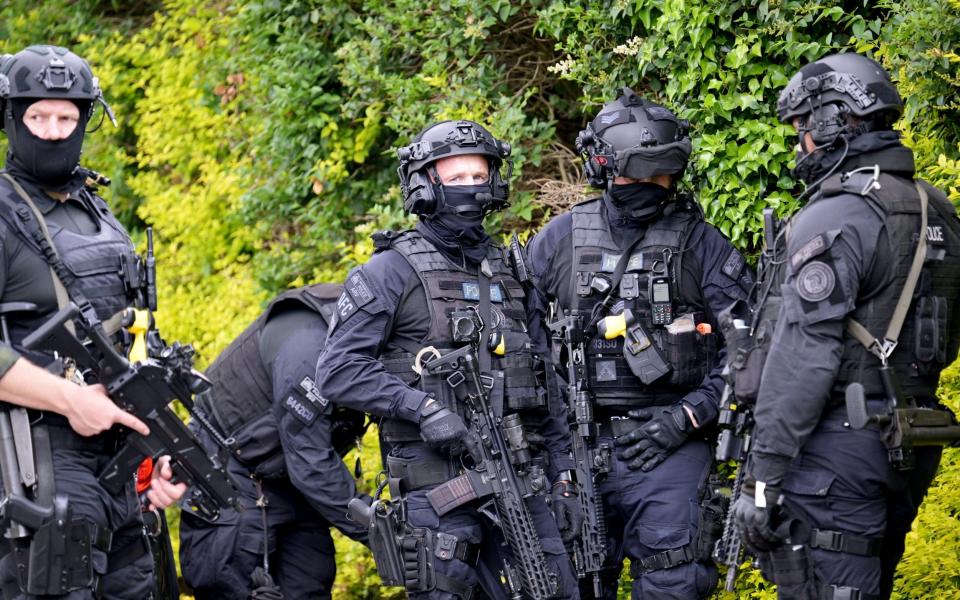 Armed police use bolt cutters to gain access to the Cooks Hole Allotment site in Enfield, as the hunt continues for Kyle Clifford, the suspect in a triple murder case