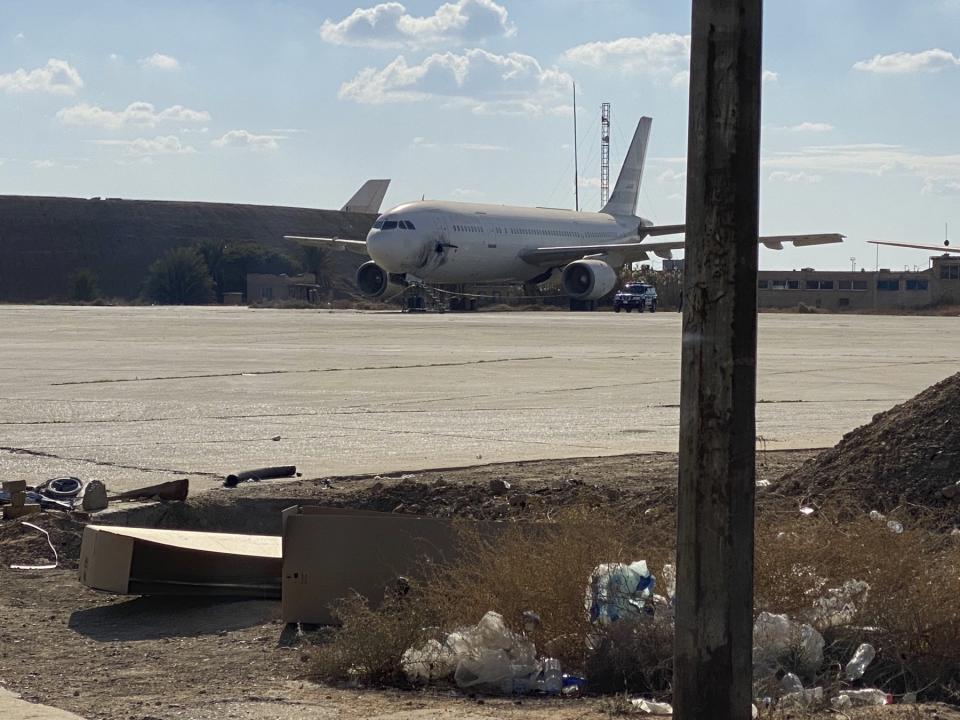 A damaged aircraft sits on the tarmac of Baghdad airport, after a rocket attack in Baghdad, Iraq, Friday, Jan. 28, 2022. At least three rockets struck near Baghdad's international airport and an adjacent military base that hosts U.S. and other coalition advisors on Friday, damaging an abandoned commercial plane but causing no casualties, Iraqi officials said. (AP Photo/Ali Abdul Hassan)