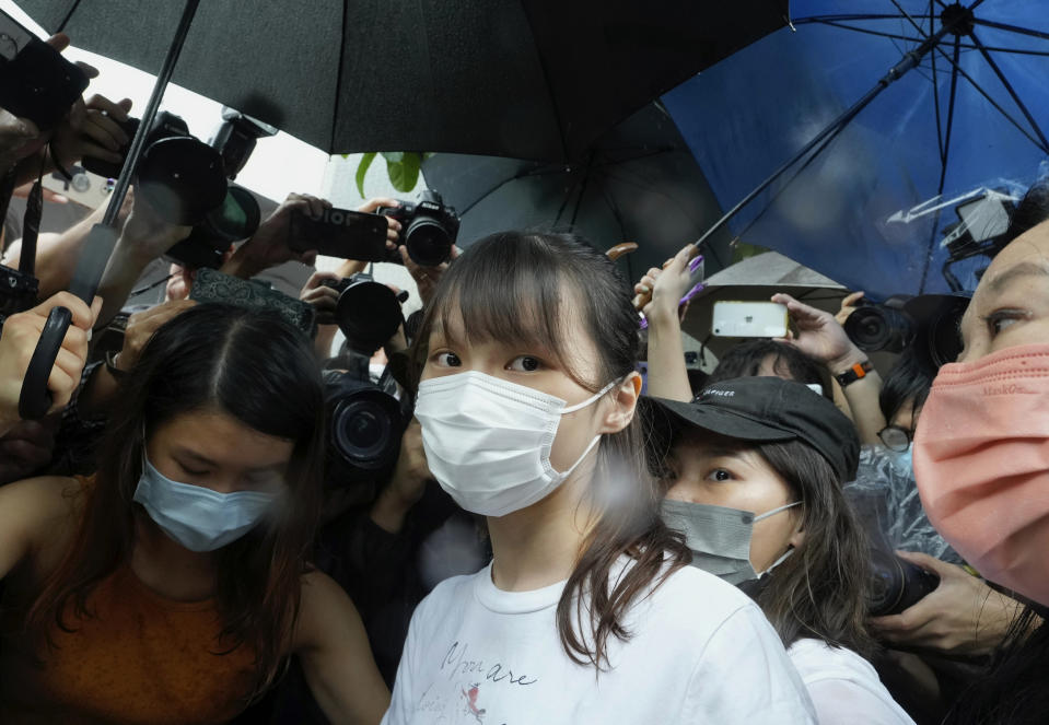 Agnes Chow, center, a prominent pro-democracy activist who was sentenced to jail last year for her role in an unauthorized protest, is released in Hong Kong Saturday, June 12, 2021. Chow rose to prominence as a student leader in the now defunct Scholarism and Demosisto political groups, alongside other outspoken activists such as Joshua Wong and Ivan Lam. (AP Photo/Vincent Yu)