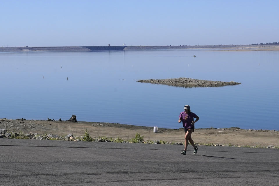 Tia Bell runs up the Folsom Lake boat ramp that is normally underwater in Folsom, Calif., Monday, Oct. 3, 2022. The reservoir is filled to about 70% of its historical average as California began its new water year that started Oct. 1. The past three years have been California's driest on record and state officials said Monday that they're preparing for the streak to continue. (AP Photo/Rich Pedroncelli)