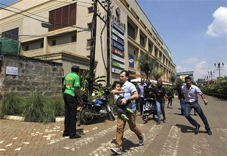 Customers run following a shootout between unidentified armed men and the police at the Westgate shopping mall in Nairobi September 21, 2013. REUTERS/Thomas Mukoya