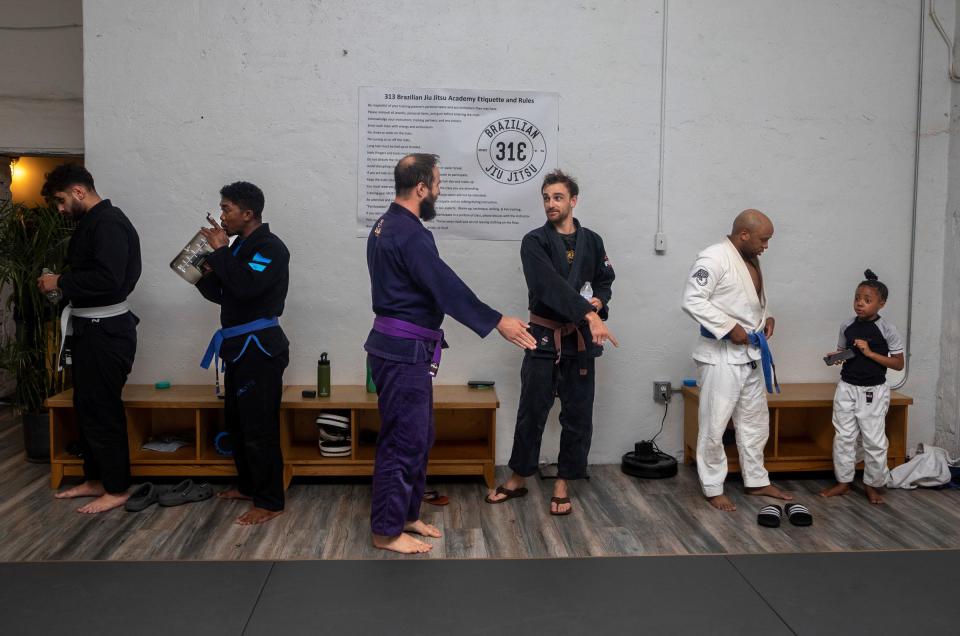 Zach Mabey, 31, a brown belt in Brazilian jujitsu (BJJ), talks with a training partner during a jujitsu session inside the 313 Brazilian Jiu Jitsu gym in Detroit on Wednesday, Aug.16, 2023.