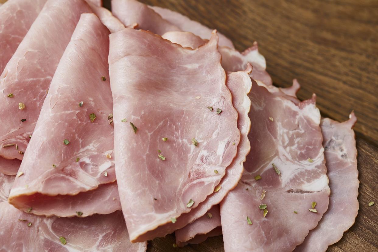 Dry pork meat with rosemary, served on a wooden cutting board, on a home, bar or restaurant table, a close up image with a copy space, macro image