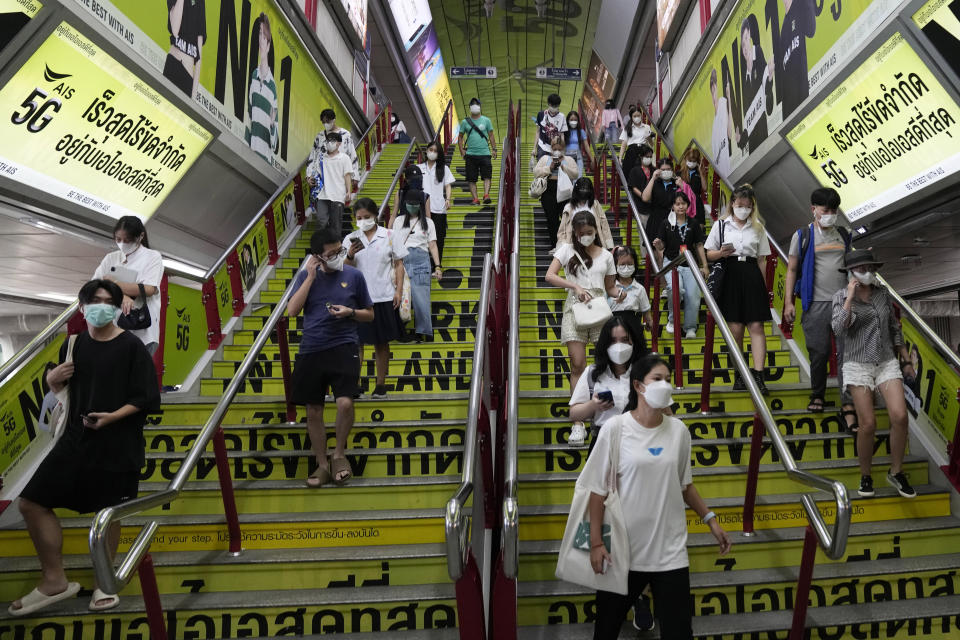Commuters wearing face masks to help curb the spread of the coronavirus at a skytrain station in Bangkok, Thailand, Friday, Sept. 23, 2022. Thai officials announced Friday that Sept. 30 will mark the last day of a state of emergency originally imposed to control the spread of the coronavirus, as they also drop virtually all restrictions, such as entry requirements for visitors from abroad. (AP Photo/Sakchai Lalit)
