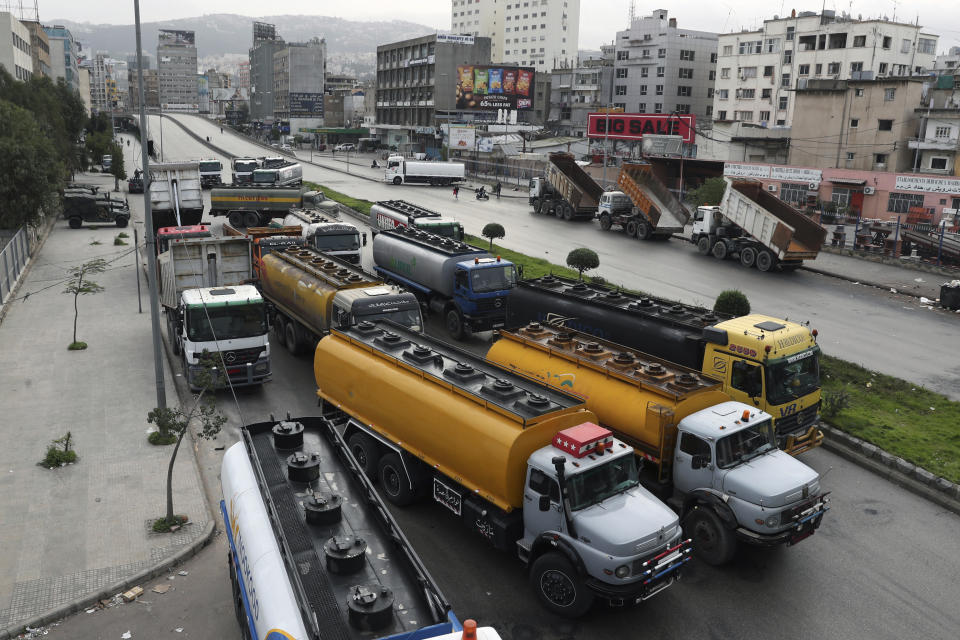 Truck drivers block a main highway with their vehicles during a general strike by public transport and workers unions paralyzed Lebanon in protest to the country's deteriorating economic and financial conditions, in Beirut, Lebanon, Thursday, Jan. 13, 2022. (AP Photo/Bilal Hussein)