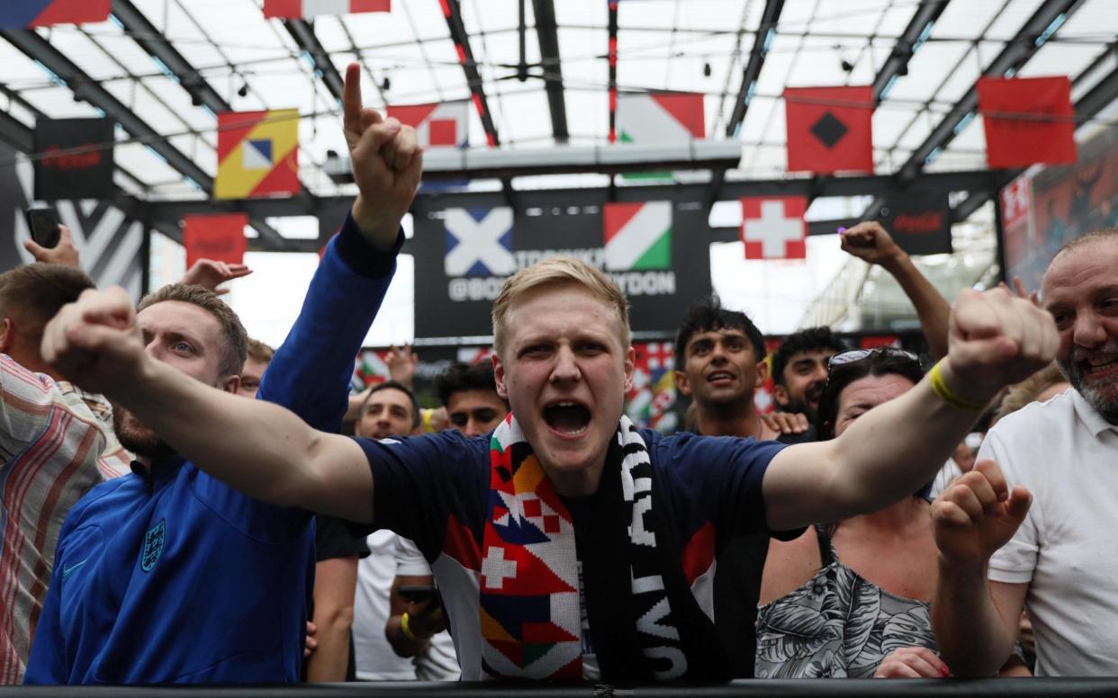 England fans react as they watch a broadcast on a large screen at Boxpark Croydon