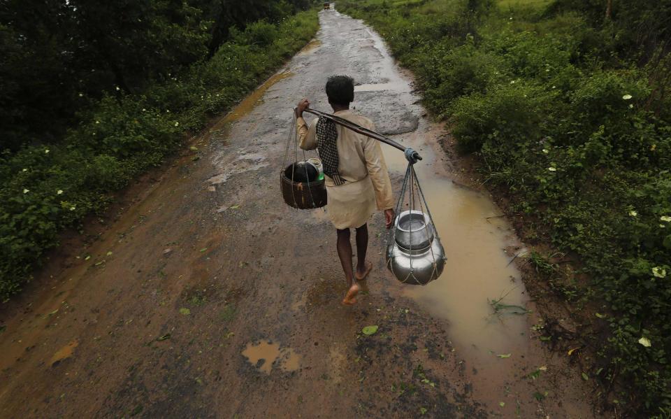 A man carrying his belongings walks towards a safer place at the village Donkuru