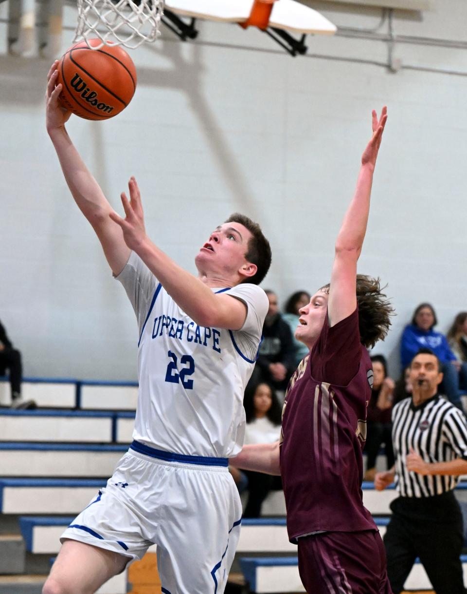 BOURNE 01/08/24 Tyler Kutil of Upper Cape Tech goes to the hoop as Trevor Ryone of Cape Tech closes in.