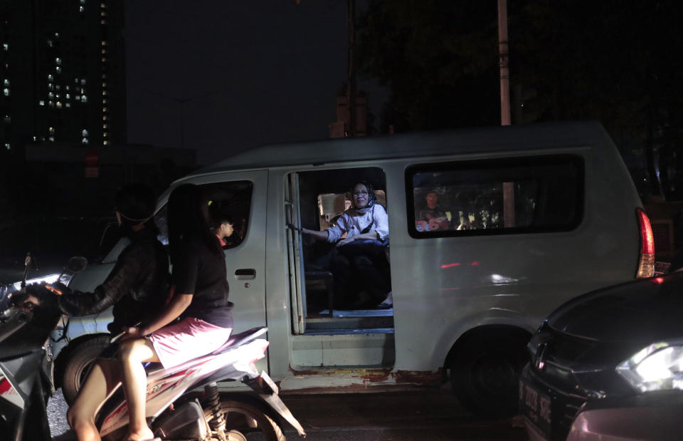 A woman sits inside a public van as it is stuck in traffic during a power outage in Jakarta, Indonesia, Sunday, Aug. 4, 2019. Indonesia's sprawling capital and other parts of Java island have been hit by a massive power outage affecting millions of people. (AP Photo/Dita Alangkara)