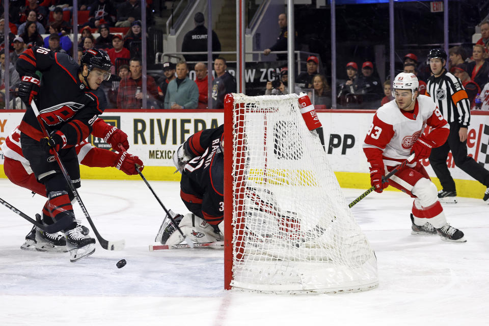 Carolina Hurricanes' Teuvo Teravainen (86) clears the puck from the crease after Detroit Red Wings' Alex DeBrincat (93) slipped it past Hurricanes goaltender Antti Raanta (32) during the first period of an NHL hockey game in Raleigh, N.C., Friday, Jan. 19, 2024. (AP Photo/Karl B DeBlaker)