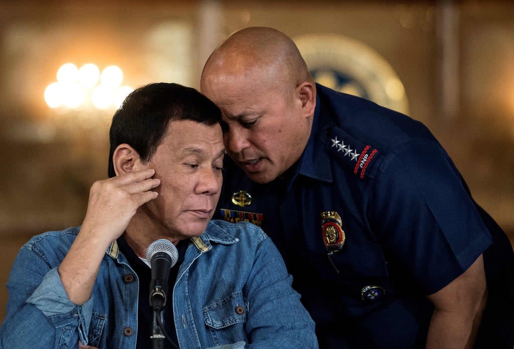 File Rodrigo Duterte (L) talking to then Philippine National Police (PNP) director general Ronald Dela Rosa (R) during a press conference at the Malacanang palace in Manila. (POOL/AFP via Getty Images)