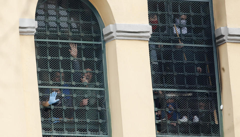 Inmates stand behind bars at the San Vittore prison as protests broke out following restrictions that were imposed on family visits to prevent coronavirus transmissions, in Milan, Italy, Monday, March 9, 2020. Italian penitentiary police say six inmates protesting virus containment measures at the northern Italian prison of Modena have died after they broke into the infirmary and overdosed on methadone. The protest Sunday in Modena was among the first of more than two-dozen riots at Italy's overcrowded lock-ups that grew Monday. (AP Photo/Antonio Calanni)