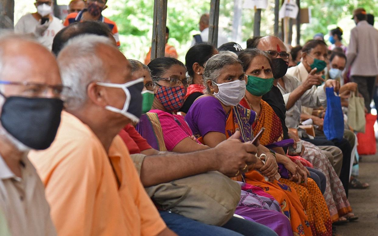 People wait to receive a coronavirus vaccine in Mumbai  - AFP