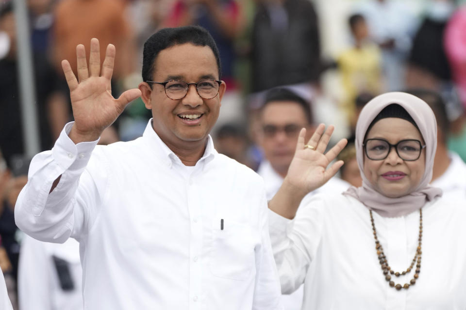 Presidential candidate Anies Baswedan, left, and his wife Fery Farhati wave as they arrive to give their vote at a polling station during the election in Jakarta, Indonesia, Wednesday, Feb. 14, 2024. Indonesian voters were choosing a new president Wednesday as the world's third-largest democracy aspires to become a global economic powerhouse a quarter-century after shaking off a brutal dictatorship. (AP Photo/Tatan Syuflana)