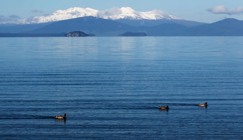 The volcanic peaks of Mounts Tongariro, Ngarruhoe and Ruapehu rise over the shores of Lake Taupo September 28, 2011. Taupo, known for it's natural scenic beauty and outdoor activities, is one of many New Zealand towns hoping for an economic boost from the 2011 Rugby World Cup. REUTERS/Mike Hutchings