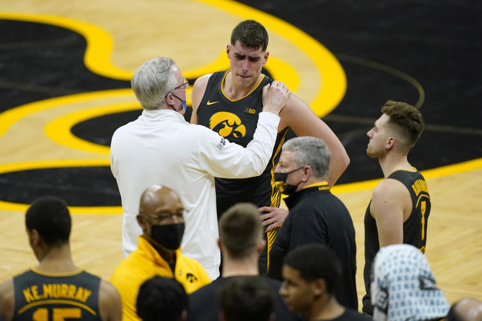 Iowa head coach Fran McCaffery, left, talks with center Luka Garza, center, and guard Jordan Bohannon, right, after an NCAA college basketball game against Wisconsin, Sunday, March 7, 2021, in Iowa City, Iowa. Garza, a senior, was playing his last home game at Iowa. Iowa won 77-73. (AP Photo/Charlie Neibergall)