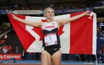 Brianne Theisen-Eaton of Canada celebrates her first place finish with the flag after the Women's Heptathlon at the 2014 Commonwealth Games in Glasgow, Scotland, July 30, 2014 REUTERS/Suzanne Plunkett